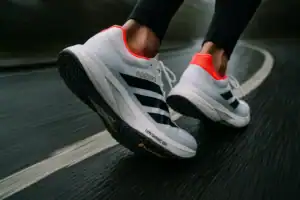 Adidas Adizero Pro 4 running shoes on a track. Performance footwear for marathons and road racing.